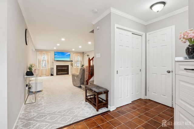 foyer entrance with a glass covered fireplace, recessed lighting, stairs, ornamental molding, and baseboards
