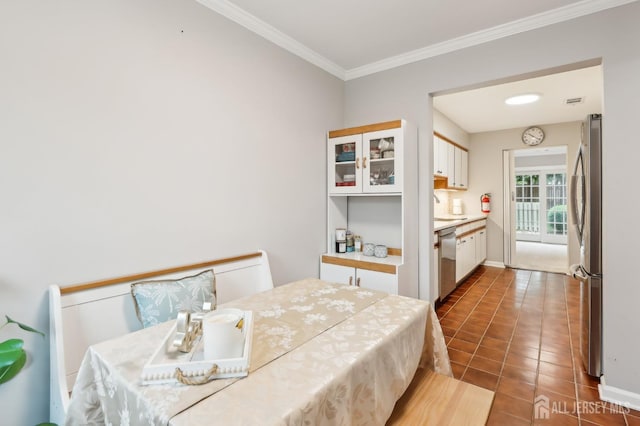 bedroom featuring freestanding refrigerator, a sink, crown molding, and tile patterned floors