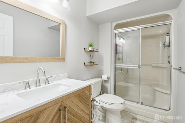 bathroom featuring a stall shower, toilet, vanity, and tile patterned flooring