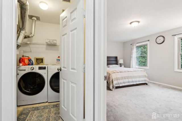 laundry area with washing machine and clothes dryer, carpet flooring, and baseboards