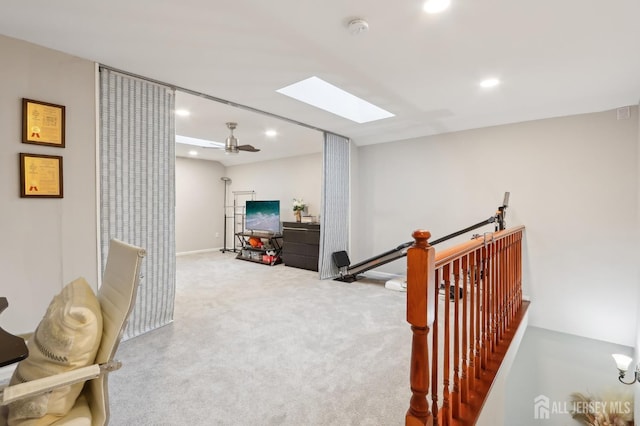 corridor featuring a skylight, an upstairs landing, recessed lighting, carpet, and baseboards