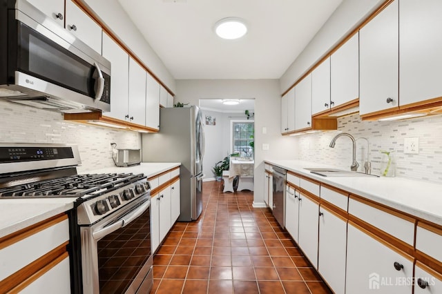 kitchen with appliances with stainless steel finishes, a sink, white cabinetry, and light countertops