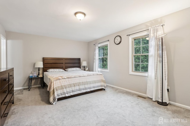 bedroom with light colored carpet and baseboards