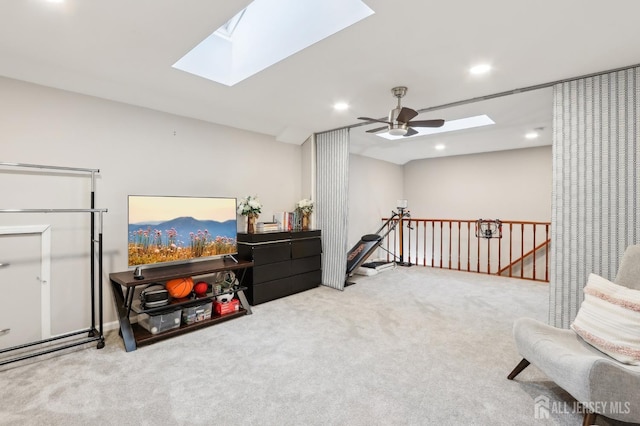 sitting room featuring a skylight, an upstairs landing, carpet flooring, recessed lighting, and ceiling fan