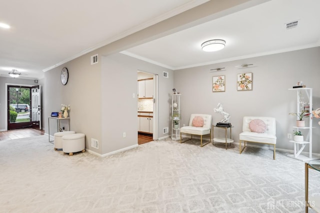 sitting room featuring crown molding, carpet flooring, and baseboards