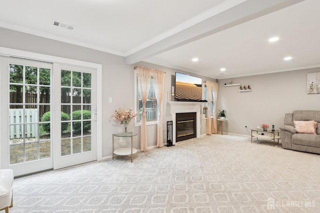 carpeted living room with recessed lighting, baseboards, ornamental molding, and a glass covered fireplace