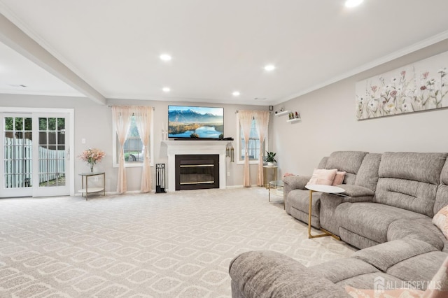 carpeted living room with recessed lighting, a glass covered fireplace, crown molding, and baseboards