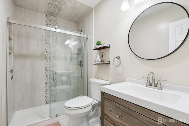 full bath featuring toilet, vanity, and a stall shower