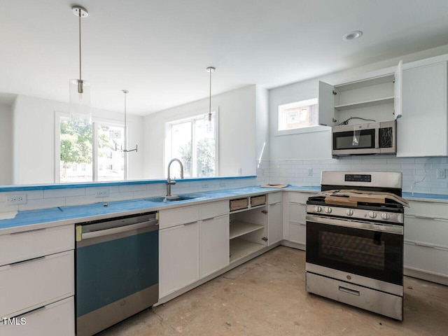 kitchen with sink, decorative light fixtures, backsplash, white cabinetry, and appliances with stainless steel finishes