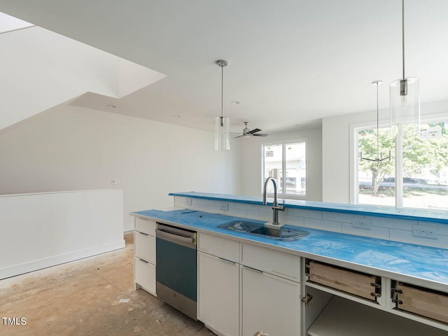 kitchen featuring pendant lighting, stainless steel dishwasher, sink, and white cabinetry