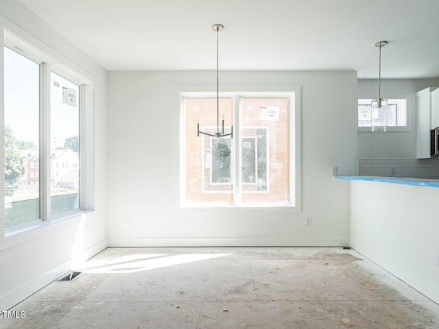 unfurnished dining area featuring a chandelier