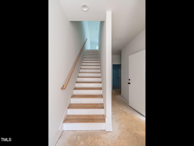 stairs with concrete flooring