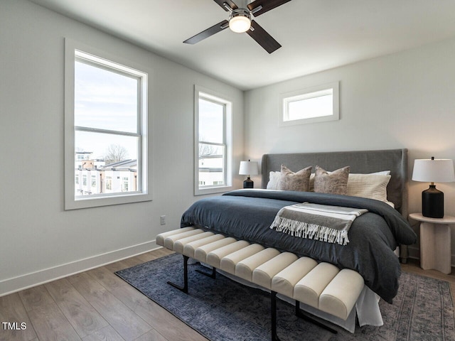 bedroom featuring a ceiling fan, baseboards, and wood finished floors