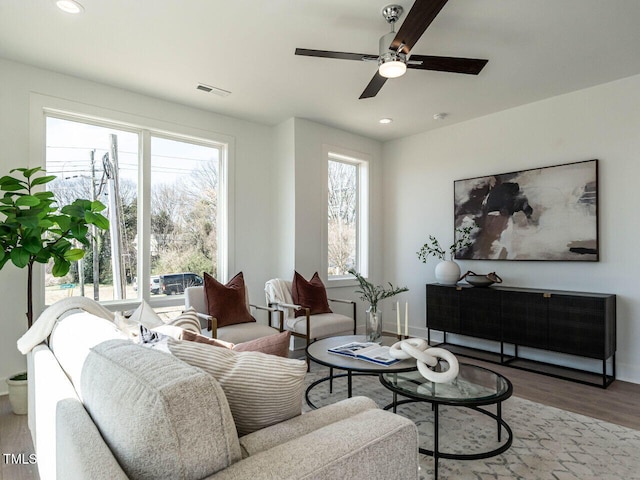 living room featuring recessed lighting, wood finished floors, visible vents, and a wealth of natural light