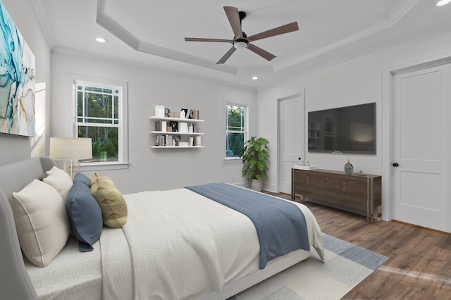 bedroom featuring a tray ceiling, ceiling fan, ornamental molding, and dark hardwood / wood-style floors