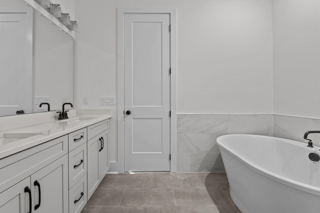 bathroom featuring tile patterned flooring, vanity, tile walls, and a washtub