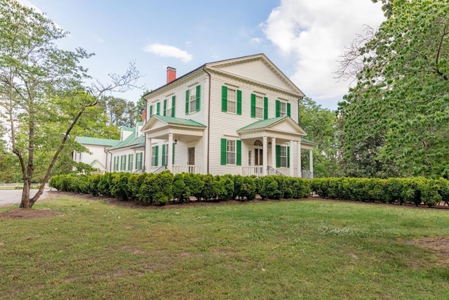 rear view of house with a porch and a lawn