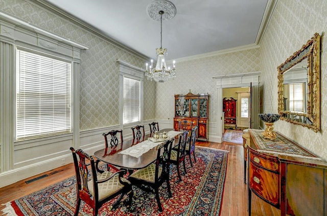 dining space featuring an inviting chandelier, crown molding, and light wood-type flooring