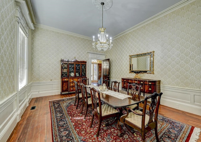 dining area featuring an inviting chandelier, dark hardwood / wood-style floors, and ornamental molding