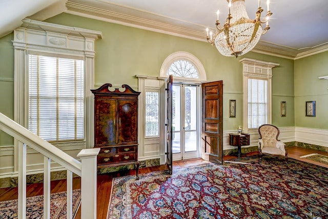 foyer entrance featuring wood-type flooring, a healthy amount of sunlight, and a chandelier