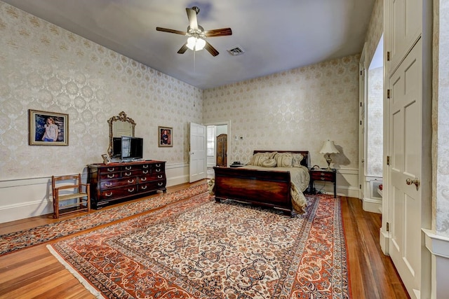 bedroom with dark hardwood / wood-style flooring and ceiling fan