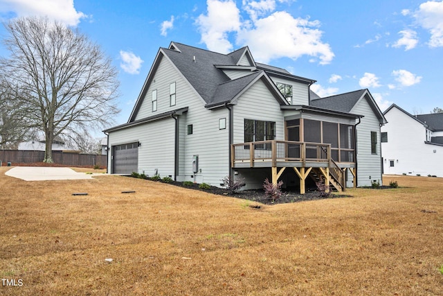 back of house with a lawn, a garage, and a sunroom