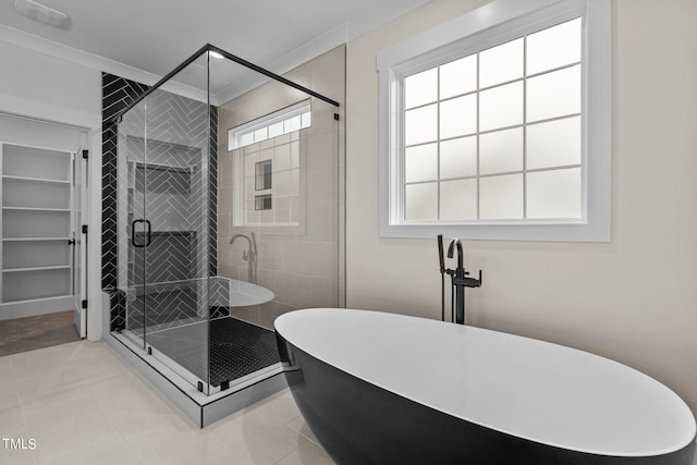 bathroom with tile flooring, a wealth of natural light, and independent shower and bath