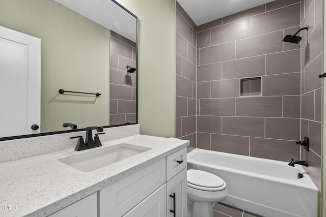 full bathroom featuring tiled shower / bath, vanity, toilet, and tile floors