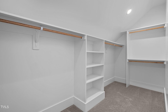 walk in closet with lofted ceiling and carpet flooring