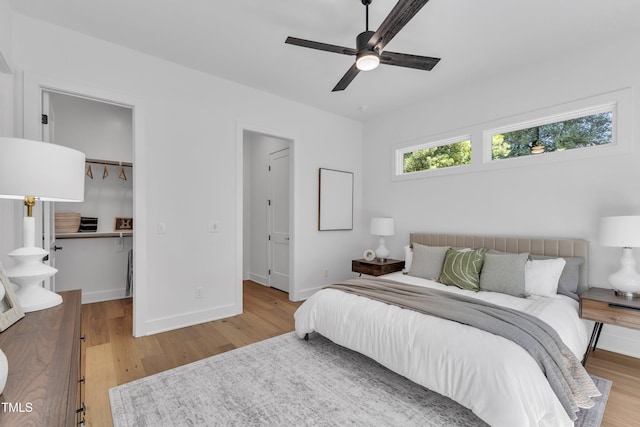 2601 Mayview Rd, Raleigh, NC 27607 - bedroom featuring baseboards, ceiling fan, a walk in closet, and light wood finished floors