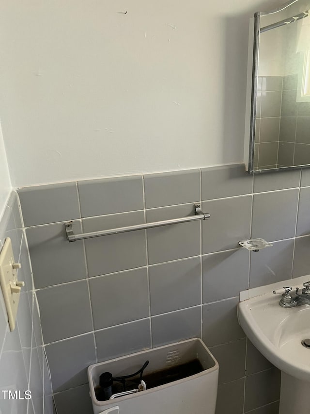 bathroom featuring sink and tile walls