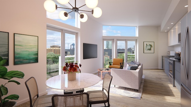 dining area featuring a notable chandelier, light hardwood / wood-style floors, french doors, and a healthy amount of sunlight