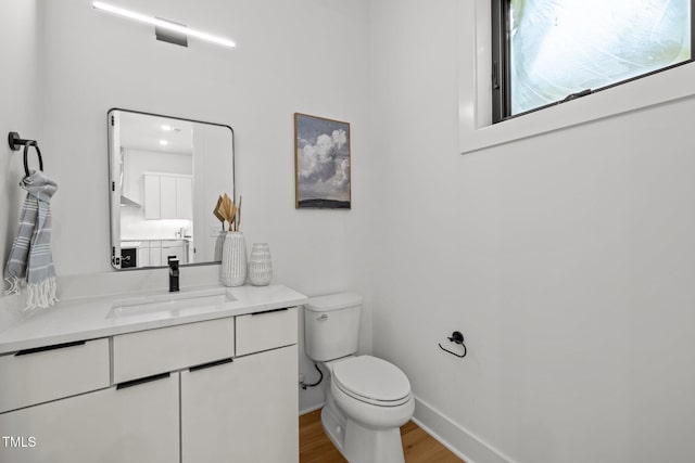 bathroom featuring vanity, toilet, and wood-type flooring