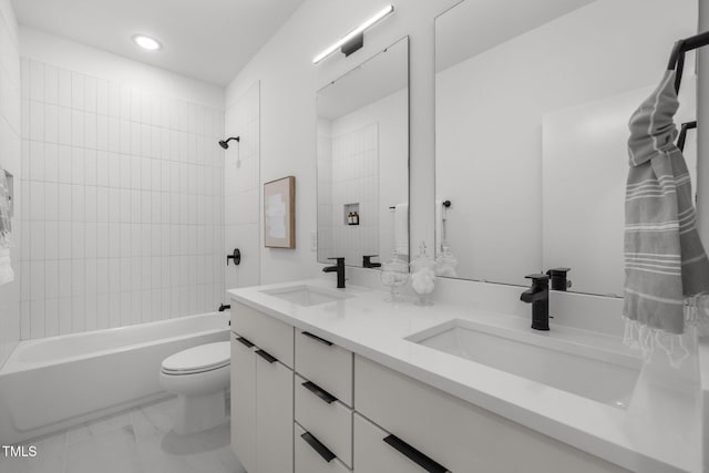 full bathroom featuring vanity, tiled shower / bath combo, and toilet