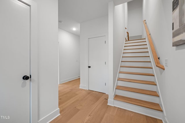 staircase with hardwood / wood-style floors