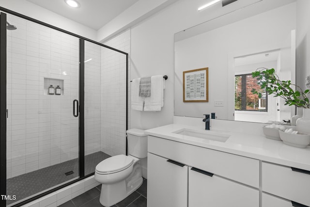 bathroom with tile patterned floors, vanity, toilet, and walk in shower