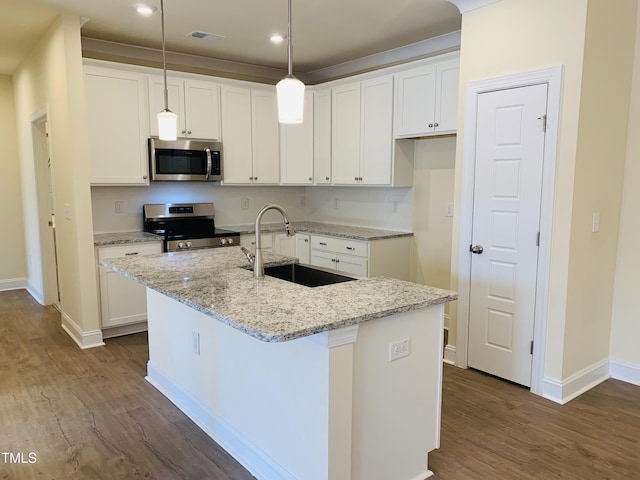 kitchen with white cabinetry, stainless steel appliances, sink, and a center island with sink