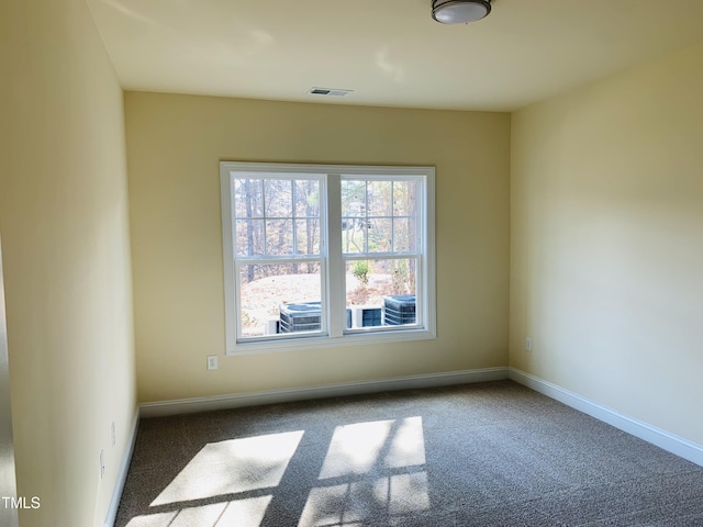 spare room with dark carpet