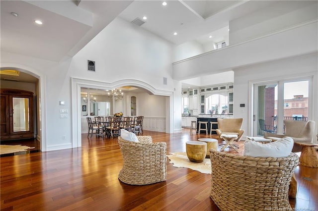 living room featuring a chandelier, hardwood / wood-style floors, and high vaulted ceiling