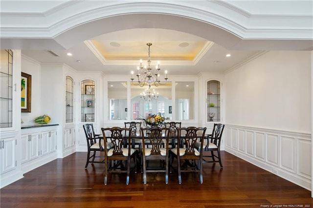 dining space featuring a raised ceiling, dark hardwood / wood-style floors, crown molding, and a notable chandelier