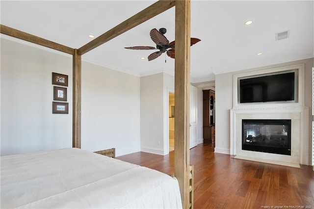 bedroom with dark hardwood / wood-style floors, crown molding, a multi sided fireplace, and ceiling fan