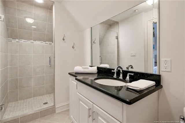 bathroom featuring tile patterned floors, a shower with door, and vanity