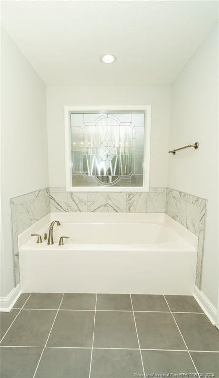 bathroom featuring tile flooring and a tub