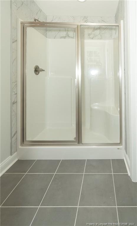 bathroom featuring tile flooring and an enclosed shower