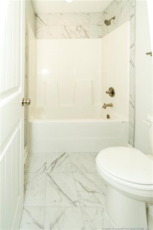 bathroom featuring toilet, tile floors, and tiled shower / bath combo