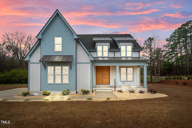 modern inspired farmhouse with a yard and a porch