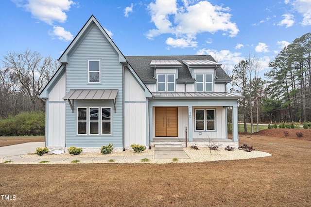 modern farmhouse featuring covered porch and a front lawn