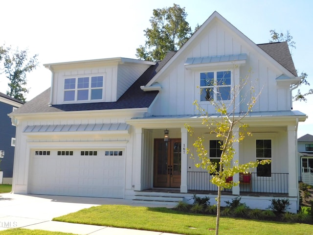 view of front of home featuring a porch, a garage, and a front lawn