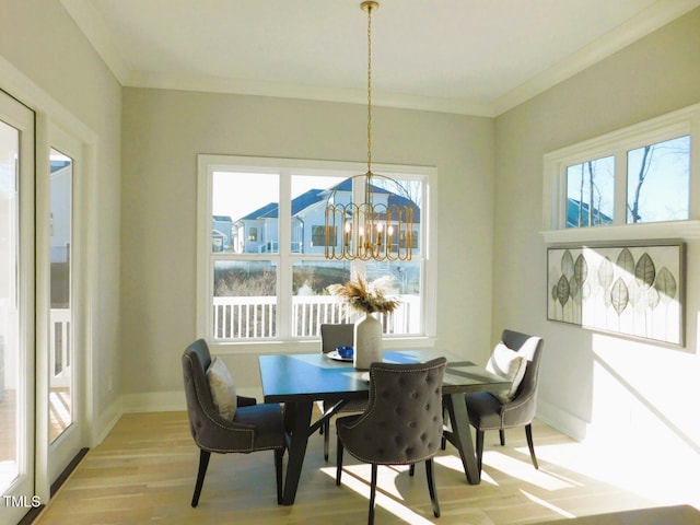 dining area featuring an inviting chandelier, plenty of natural light, ornamental molding, and light wood-type flooring