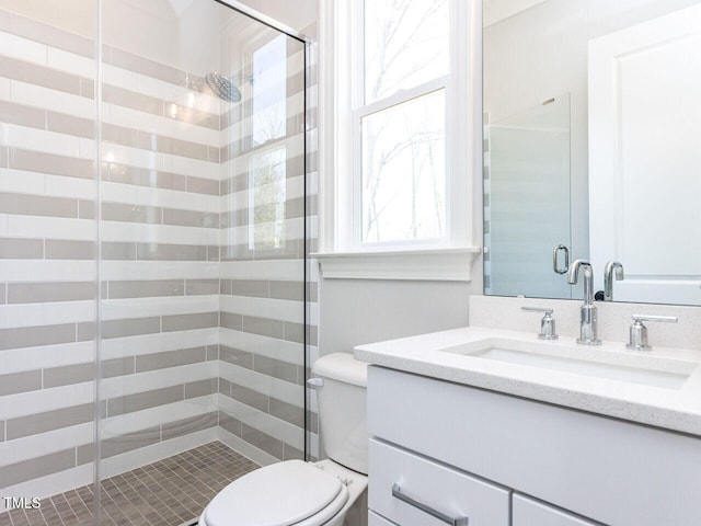 full bath featuring a stall shower, vanity, and toilet